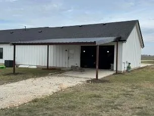 Covered carport and patio cover built onto a white barn-style home